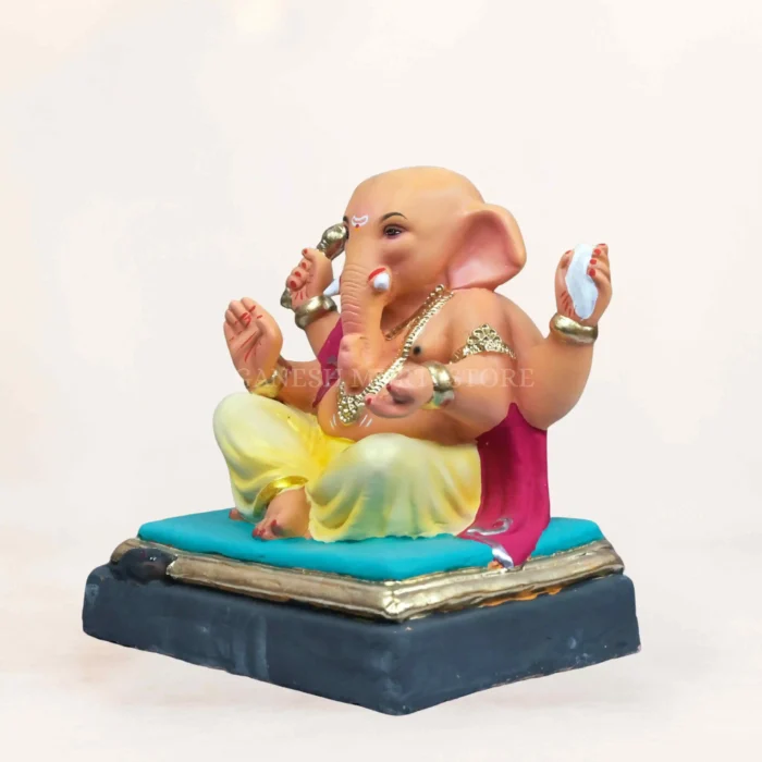 Side profile view of 12 inch eco friendly clay Ganpati idol with detailed traditional carvings in light yellow.