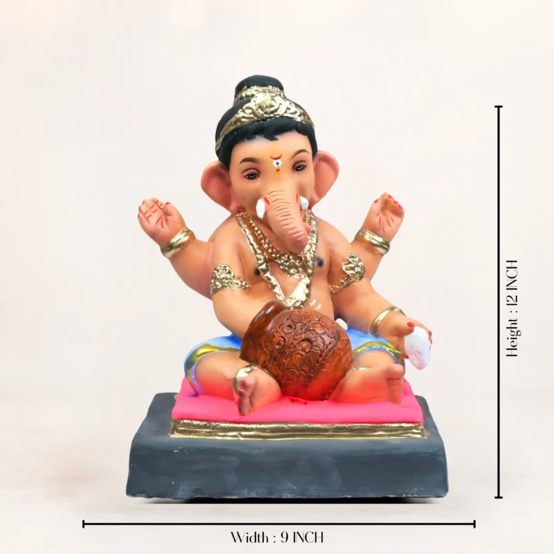 natural clay Ganesha idol sitting in a meditative posture. The handcrafted idol features intricate detailing on the crown and garments, placed neatly inside a decorative golden brass urli filled with fresh red rose petals and green leaves.