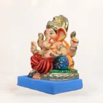 Eco-friendly clay Ganesh idol undergoing home immersion process in a bucket of water.