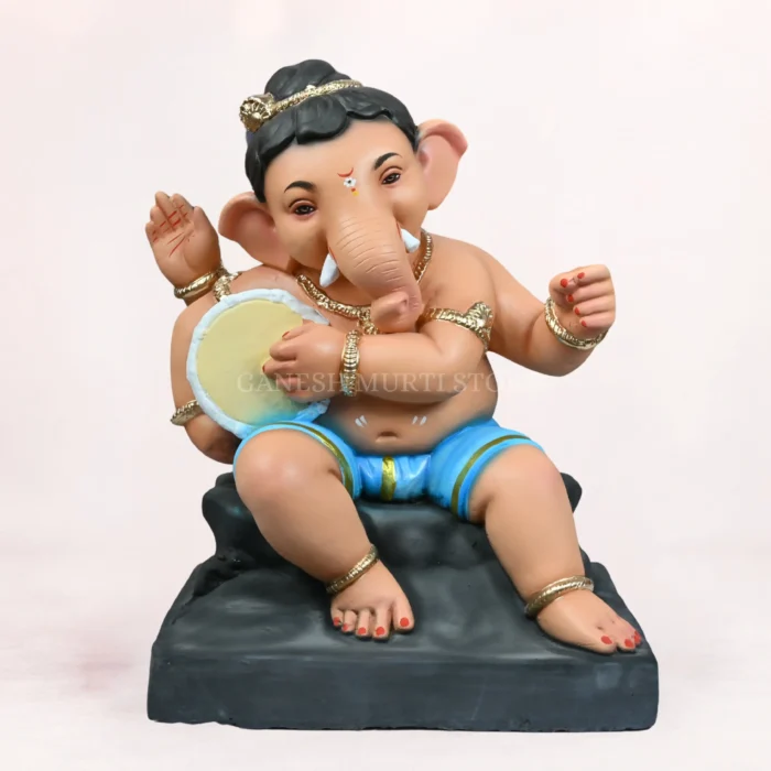 Cow Bal Sky Blue Dhoti 20 Inch Eco-Friendly Ganpati Idol Cow Bal Sky Blue Dhoti 20 Inch Eco-Friendly Clay Ganpati Idol leaning against a beautifully painted holy cow figurine