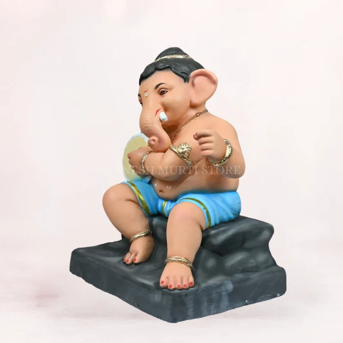 Detailed view of Cow Bal Sky Blue Dhoti 20 Inch Eco-Friendly Clay Ganpati Idol sitting comfortably next to a sacred cow figure